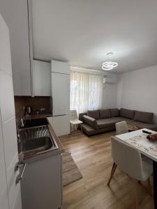 a kitchen and living room with a couch and a table at Estel Apartament in Tirana