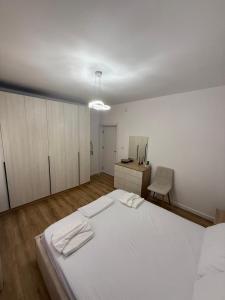 a bedroom with a large white bed and a desk at Estel Apartament in Tirana