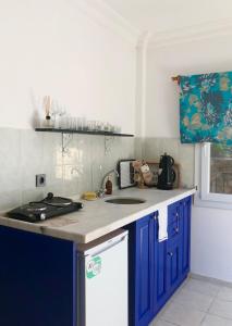 a kitchen with blue cabinets and a counter top at Deka apartments 5 in Fethiye