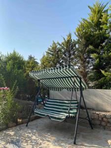 a swing with a striped umbrella in a yard at Deka apartments 5 in Fethiye