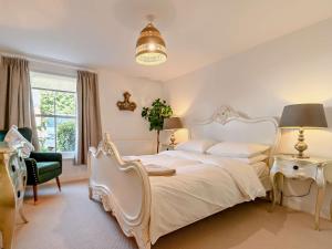 a bedroom with a white bed and a chair at 1 Bed in cotswolds 90128 in Cirencester