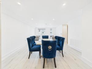 a dining room with a table and blue chairs at Preston Street Apartments - by the Brighton i360 in Brighton & Hove
