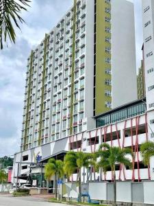 un grand bâtiment avec des palmiers devant dans l'établissement Playground Studio in Kuantan, à Kuantan