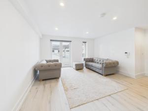 a living room with two couches and a rug at Preston Street Apartments - by the Brighton i360 in Brighton & Hove