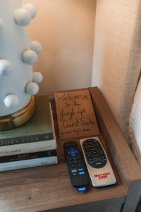 Eine Fernbedienung liegt auf einem Tisch neben Büchern. in der Unterkunft Wilmington Luxury Spa Retreat- Prime Location in Wilmington