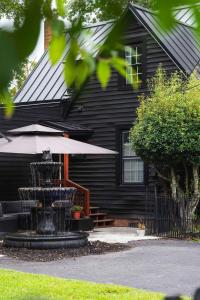 ein schwarzes Haus mit einem Brunnen davor in der Unterkunft Wilmington Luxury Spa Retreat- Prime Location in Wilmington