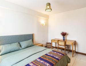 a bedroom with a bed and a table at Diamond Ivy Two Bedroom Apartment, Swimming pool, gym, workspace ,Wonderiss Homes Kileleshwa Living in Nairobi