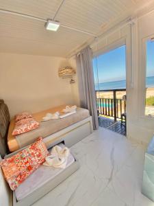 a room with two beds and a balcony with the ocean at Pousada São Miguel Beach Beira Mar in Penha