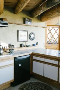 a kitchen with a counter and a clock on the wall at Unique and Modern Lodging with Exceptional Features in Paradise Valley, Montana in Flying Y Ranch Airport