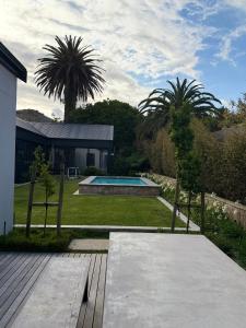 Un patio trasero con piscina y una casa. en Mitchells Hermanus Gem, en Hermanus