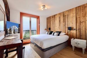 ein Schlafzimmer mit Bett, Schreibtisch und Fenster in der Unterkunft New new duplex apartment near runway in Saint-Bon-Tarentaise