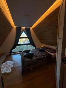 BorsaにあるRiverside A-frameの窓のある部屋にベッドがある寝室