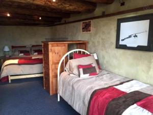 a bedroom with two beds and a flat screen tv at Unique and Modern Lodging with Exceptional Features in Paradise Valley, Montana in Flying Y Ranch Airport