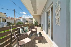 ein Balkon mit Korbstühlen und einem Tisch in der Unterkunft Filoxenia MG Amazon Home in Nafplio