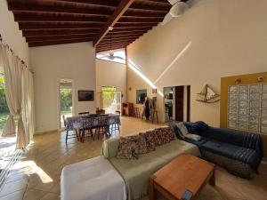 a living room with a couch and a table at Praia de Itamambuca- Casa charmosa e iluminada in Ubatuba