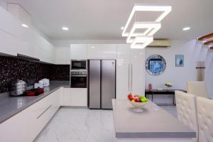 a white kitchen with a bowl of fruit on a table at Wonderland Sapphire 8 Bedroom Luxury Villa in Pattaya South