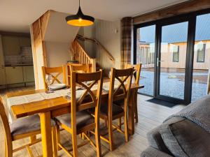 a dining room with a wooden table and chairs at Remore Steading - Coachhouse in Ardclach +29 photos