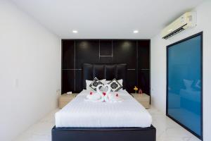 a bedroom with two cats sitting on a bed at Wonderland Sapphire 8 Bedroom Luxury Villa in Pattaya South