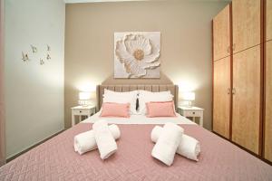 ein Schlafzimmer mit einem Bett mit rosa und weißen Kissen in der Unterkunft Filoxenia MG Amazon Home in Nafplio