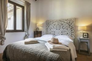 Un dormitorio con una cama con un sombrero encima. en Historic Apartment With San Gimignano Hills View, en Villa del Monte