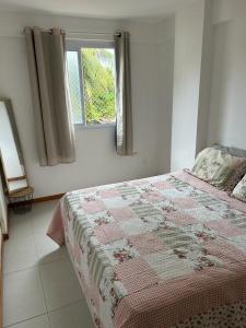 een slaapkamer met een bed en een raam bij Ap Villa Toscana in Ilhéus