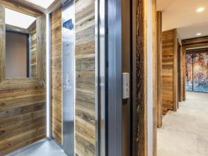 a pivot door in a hallway with wooden walls at Chalet de luxe avec piscine, sauna, hammam, cinéma et salle de jeu - FR-1-694-3 in Val dʼIsère +20 photos