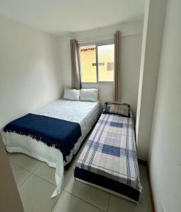 een kleine slaapkamer met een bed en een raam bij Ap Villa Toscana in Ilhéus