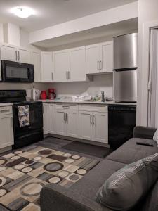 eine Küche mit weißen Schränken und einem Herd mit Backofen in der Unterkunft MegaVille in Saskatoon