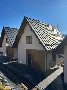 un revestimiento de una casa con techo de metal en Rusiński Raj - Domki, en Bukowina Tatrzańska