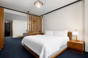 a bedroom with a large white bed and a lamp at Le Meridien New York, Central Park in New York