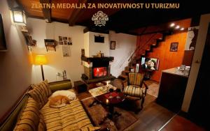 a living room with a couch and a fireplace at Brvnare - Ranč Platan in Vrdnik