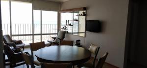 Una habitación con una mesa y sillas y un televisor. en HAVANNA APART frente al mar, en Mar del Plata