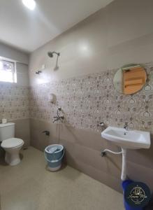 a bathroom with a sink and a toilet and a mirror at Hotel Amore Mio Morjim in Morjim