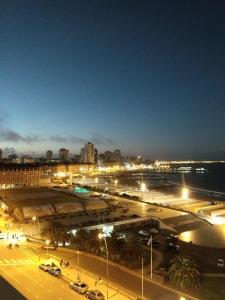 Una ciudad de noche con coches estacionados en un estacionamiento en HAVANNA APART frente al mar, en Mar del Plata