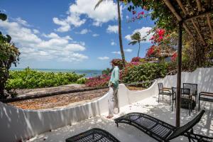 a woman standing on a balcony looking at the ocean at Enjoy Jeri Praia in Jericoacoara