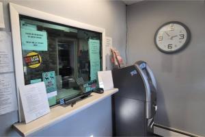 a clock on a wall next to a refrigerator at Des Plaines Motel By OYO O'Hare Airport Chicago in Des Plaines +18 photos