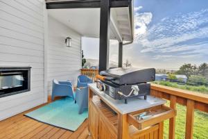 a grill on a deck with two blue chairs at Deja View - Ocean View Neskowin Luxury in Neskowin