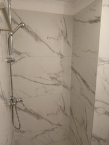 a bathroom with a shower with marble walls at Archontiko Hotel in Kalymnos