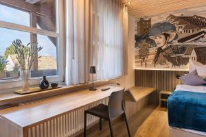 a bedroom with a desk and a bed and a window at FeWo Holzäpfel Dunningen in Dunningen