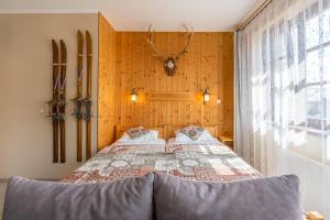 a bedroom with a bed with a antelope head on the wall at Apartman Hubert in Kašperské Hory