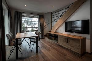 a dining room with a table and a flat screen tv at Chalet Bel Plan in Ortisei