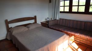 een slaapkamer met een bed, een bank en een raam bij Haras Santa Amalia - Nova União MG in União de Caeté +38 foto's
