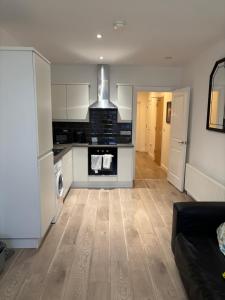 a kitchen with white cabinets and a stove top oven at Queens apartments Belfast in Belfast