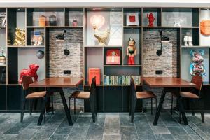 two tables and chairs in a room with shelves at citizenM Paris Champs-Élysées in Paris +26 photos