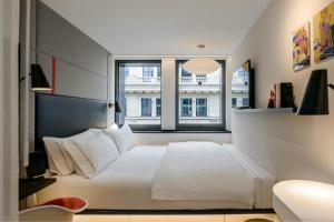 a bedroom with a white bed and a large window at citizenM Paris Champs-Élysées in Paris