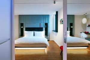 a bedroom with two beds and a bathroom with a sink at citizenM Paris Champs-Élysées in Paris