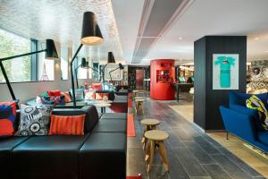 a living room with a black couch and chairs at citizenM Paris Champs-Élysées in Paris