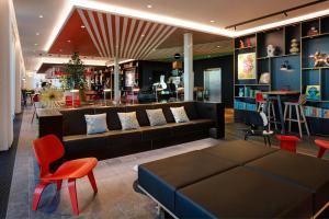 a living room with a couch and a table and chairs at citizenM Copenhagen Radhuspladsen in Copenhagen