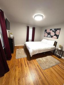 サウスベンドにある2BR Perfect Extended Stay by Notre Dame and Storesのウッドフロアのベッドルーム1室(ベッド1台付)