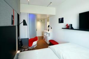 a hotel room with two beds and a tv at citizenM Zürich in Zürich